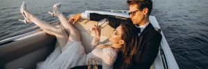 Bride and groom sitting in a boat drinking LoveLUVV Champagne